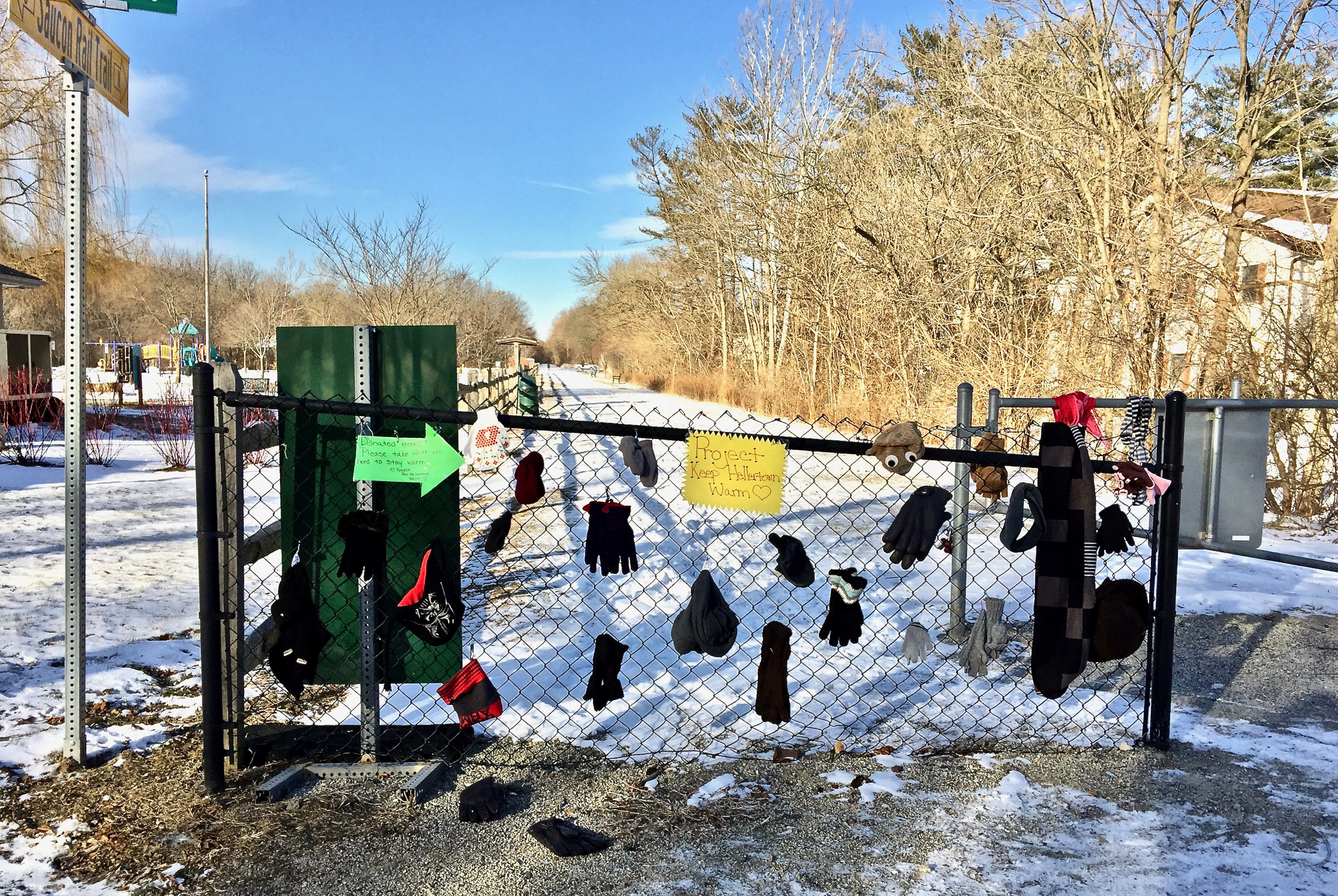 Hats, scarves, mittens, and gloves placed on the rail-trail path for those who need the items in winter. They are free to any in need.